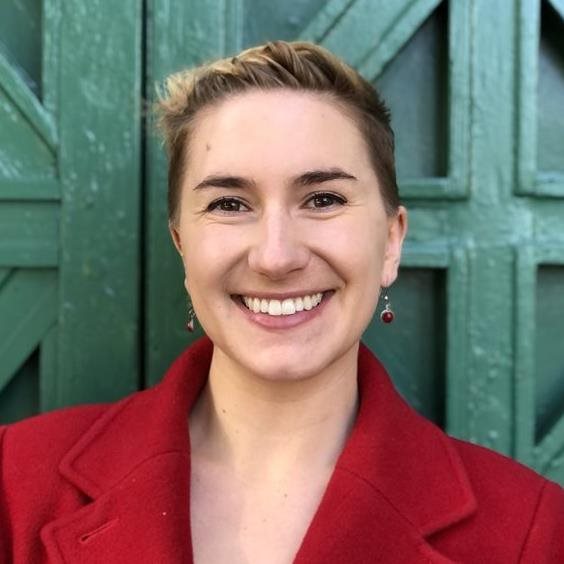 Emma Newman smiling in front of a wall